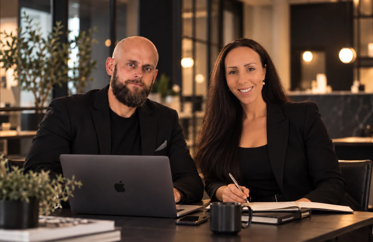 Timmi och Erika på Quma webbyrå arbetar med AI-optimering vid ett skrivbord med laptop och anteckningsbok.